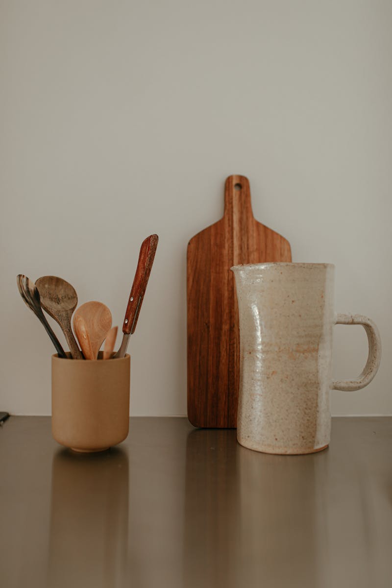 Aesthetic kitchen setup with utensils, jug, and cutting board for a rustic feel.